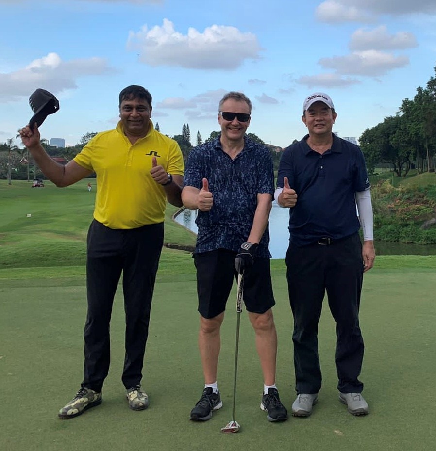 kolme miestä golf-kentällä