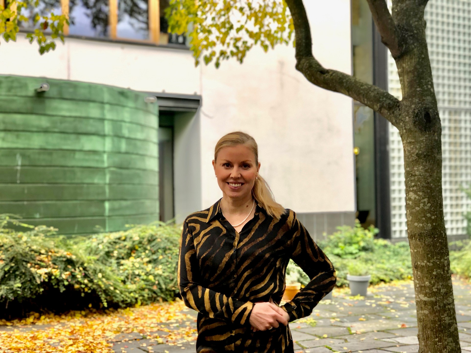 Anna Yletyinen står i ambassadens trädgård. 