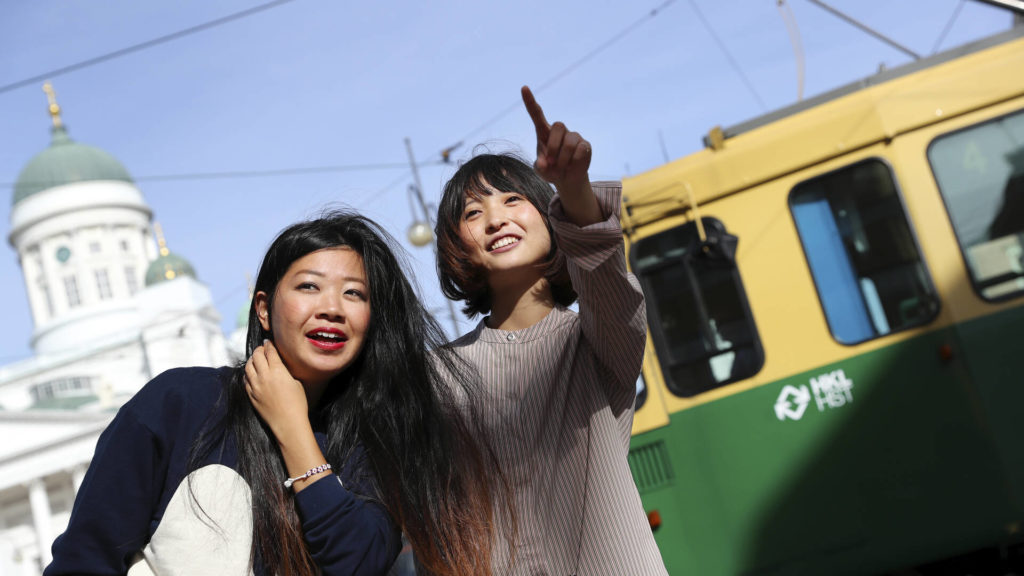 Kaksi naista ottaa selfietä raitiovaunun edessä